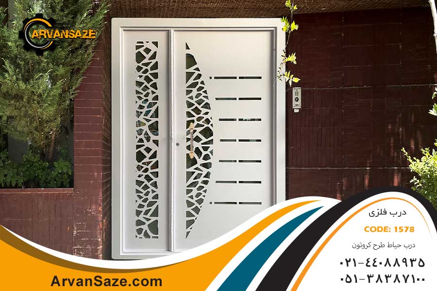 درب حیاط یک و نیم لنگه فلزی لیزری سفید رنگ با دستگیره چدنی برنجی رنگ، نصب شده روی دیوار با نمای آجر سفال تیره رنگ